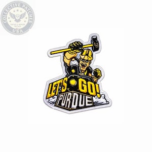May include: An embroidered patch featuring a cartoon train conductor wearing a yellow hard hat, holding a large hammer above a black steam locomotive. The text reads LET'S GO! PURDUE in bold yellow and white lettering against a white background.