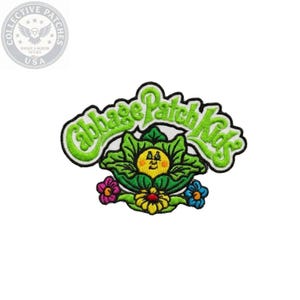 May include: An embroidered fabric patch featuring the text Cabbage Patch Kids in bright green letters. Below the text is a yellow-faced character nestled inside a green cabbage leaf, flanked by a pink flower on the left and a blue flower on the right.