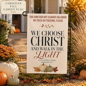 May include: A rectangular garden flag with a cream background featuring the text: THIS HOME DOES NOT CELEBRATE HALLOWEEN NO TRICK-OR-TREATING, PLEASE WE CHOOSE CHRIST AND WALK IN THE LIGHT Live as children of light. EPHESIANS 5:8 with two pumpkins and leaves.