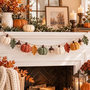 May include: A decorative garland featuring crocheted pumpkins, acorns, and oak leaves in shades of orange, green, cream, and brown, strung along a thick jute twine. The garland displays a repeating pattern of these autumn-themed textile elements.