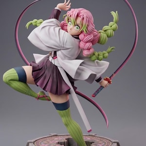 May include: A dynamic anime-style figurine of Mitsuri Kanroji from Demon Slayer, featuring pink and green braided hair, a white haori, a dark purple skirt, and green striped stockings. The character holds a long, flexible pink sword blade.