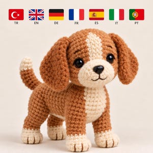 May include: A crocheted dog toy featuring brown and cream yarn. The plush figure has long floppy ears, a cream-coloured muzzle and chest, and four cream-coloured paws. It has large black plastic eyes and a small black stitched nose.