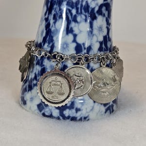 May include: A set of three ceramic mugs with a speckled, matte finish. The mugs are in shades of cream, light gray, and dark gray. Each mug has a simple, minimalist design and a rounded handle.