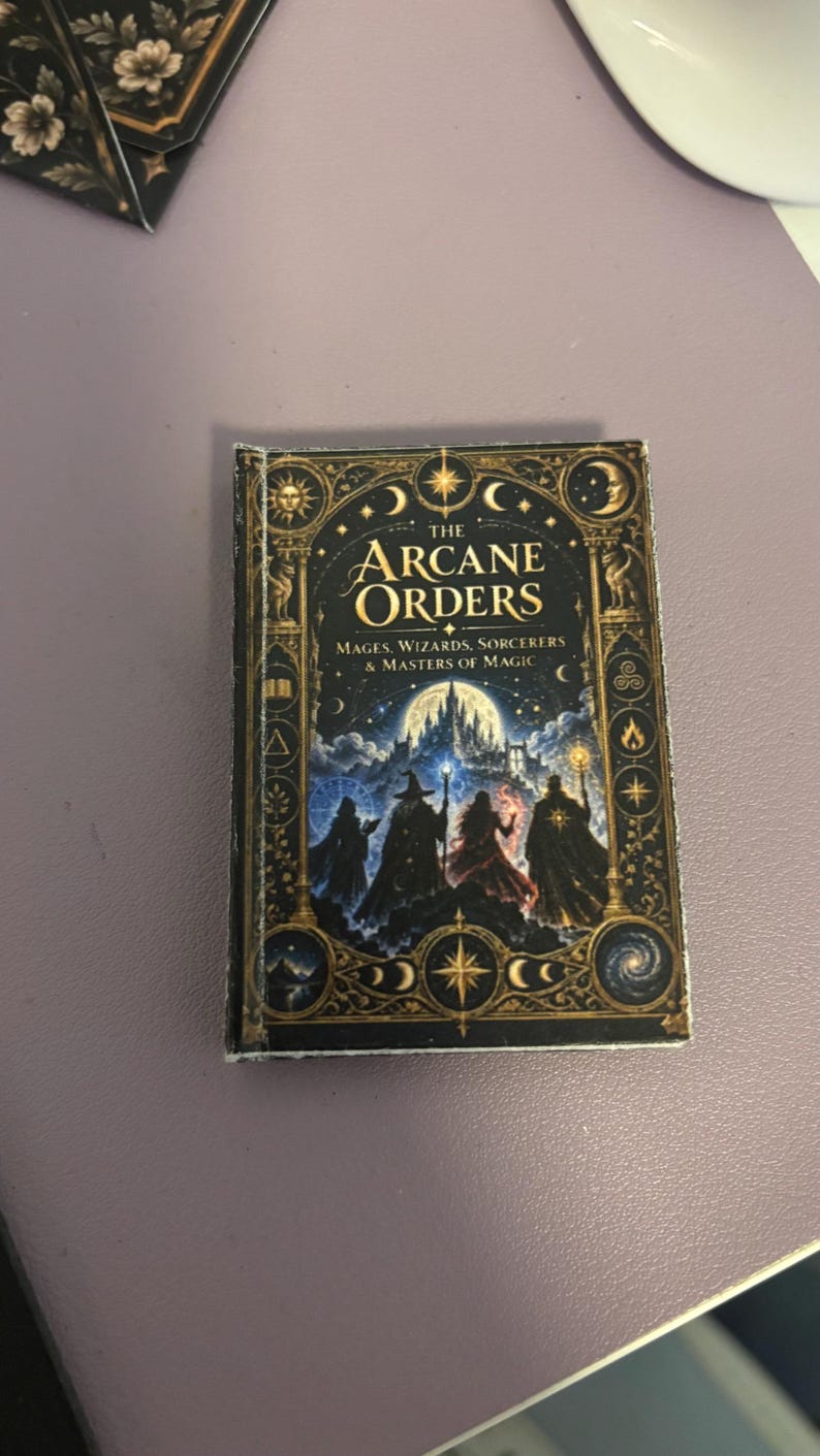 May include: A small rectangular book titled The Arcane Orders: Mages, Wizards, Sorcerers & Masters of Magic. The cover features a dark blue night sky, a large full moon, a castle, and four cloaked figures holding staffs with glowing light.