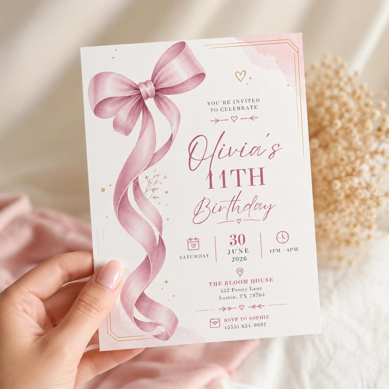 May include: A rectangular birthday invitation card featuring a large, flowing dusty pink ribbon illustration on the left side. The text reads: You're invited to celebrate Olivia's 11th Birthday, Saturday 30 June 2026, 1pm-4pm, The Bloom House, 452 Peony Lane, Austin, TX 78704, RSVP to Sophie (555) 654-0987.