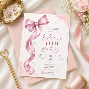May include: A rectangular birthday invitation card featuring a large, flowing pink ribbon illustration on the left side. The text reads: You're invited to celebrate Olivia's 11th Birthday, Saturday, 30 June 2026, 1pm-4pm, The Bloom House, 452 Peony Lane, Austin, TX 78704.