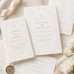 May include: A set of cream-colored wedding stationery including a Save the Date, invitation, and RSVP card. Each piece features an embossed floral border, elegant serif typography, and the names Olivia Hart and James Bennett with event details.