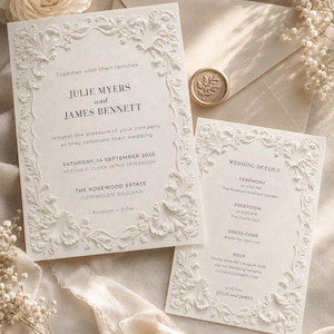 Może przedstawiać: Kremowe zaproszenie ślubne z wytłaczaną kwiatową ramką. Tekst zawiera: Julie Myers and James Bennett, Saturday, 14 September 2026, The Rosewood Estate, Cotswolds, England. W zestawie koperta ze złotą pieczęcią lakową.