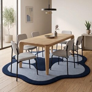 May include: A rectangular light wood dining table with four tapered legs, surrounded by six chairs featuring light gray upholstered seats and black metal frames, placed on a large, irregular, cloud-shaped rug in shades of navy and light blue.