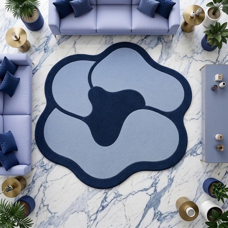 May include: An irregular, flower-shaped area rug featuring a deep navy blue border and central core, contrasted with light blue, rounded petal-like sections. The rug has a soft, textured surface and a distinct, organic, non-symmetrical silhouette.