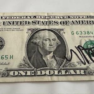 May include: A one dollar bill with a signature in black ink that says "Avatar". The bill has the serial number G63384565H.
