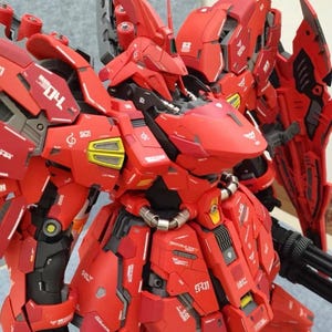 May include: A red robotic action figure model featuring intricate paneling, mechanical joints, and white decals including the text 04, S01, and various symbols. The figure has a pointed head, shoulder armor, and a complex chest plate design.