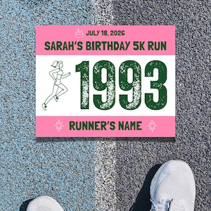 May include: A rectangular race bib with pink top and bottom borders and a white center. It features a green cake icon, the text JULY 18, 2026, SARAH'S BIRTHDAY 5K RUN, the number 1993 in large green font, a line drawing of a runner, and RUNNER'S NAME.