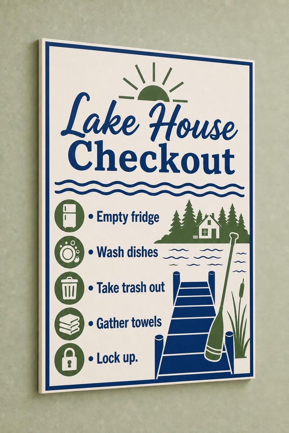 Dockside navy and green lake house checkout sign mounted on a pale-sage wall from a close side angle.