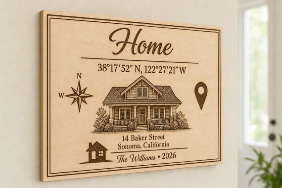 Home Coordinates engraved birch sign mounted on a neutral entry wall from a close side angle.