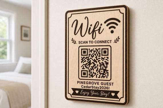 Scripted Welcome Guest WiFi Sign engraved birch sign mounted on a realistic neutral interior wall from a close side angle in natural birch and dark engraving, showing the QR code and guest network details.