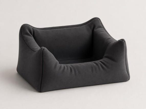 Studio close-up of the empty Plush Nook phone stand in Charcoal showing its cushion folds