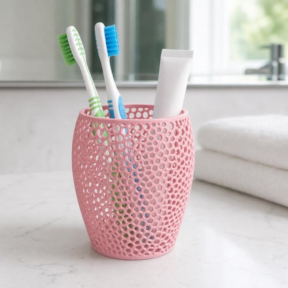 Breezewick Utility Cup, sakura pink perforated toothbrush holder on a bathroom counter