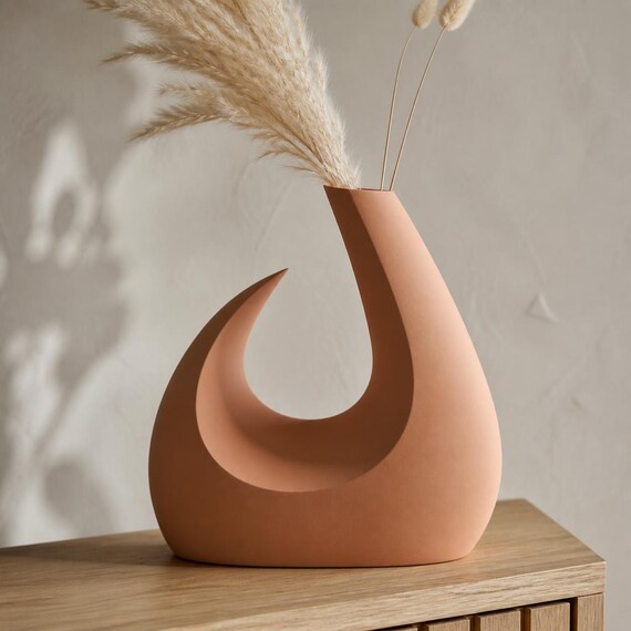 MoonGate Statement Vase, close-up lifestyle view of the Solstice Arc vase in Terracotta with dried stems