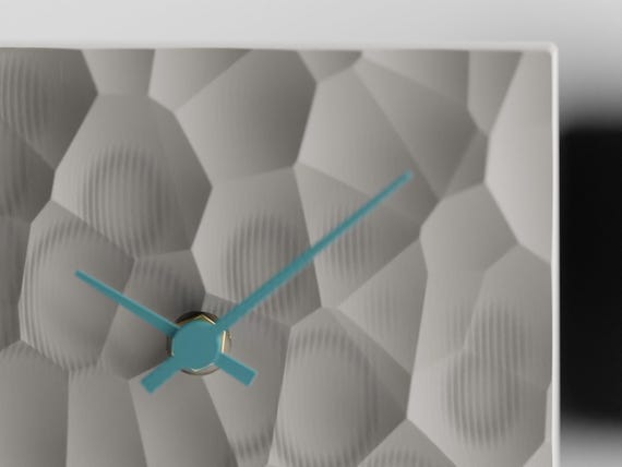 PrismHearth Table Clock, close-up of the Ash Gray faceted texture and Sky Blue clock hands