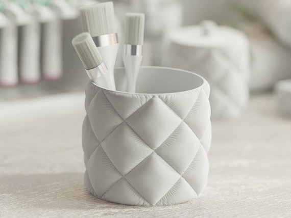 Close-up of the Cottonstay Bath Collection round organizer cup holding cosmetic brushes