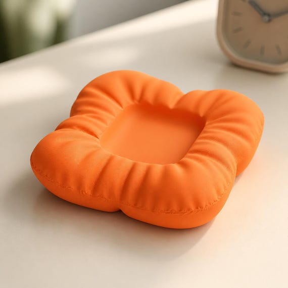 Close-up of the empty PuffNest dock in Mandarin Orange showing its fitted center recess
