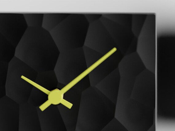 PrismHearth Table Clock, close-up of Facetfield's Charcoal organic geometric relief and Lemon Yellow hands