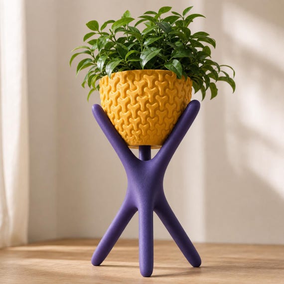 Close-up low angle of the Large HearthLift Tripod Planter planter in Indigo Purple and Gold with a leafy plant