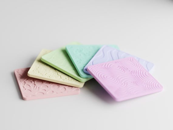Low-angle close-up of the six Patchpetal Coaster Set patterned coasters in the fixed pastel assortment