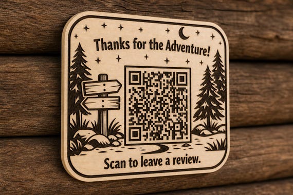 TimberQuest engraved birch forest adventure review sign mounted on a cabin wall from a close side angle with a finished sample QR code.