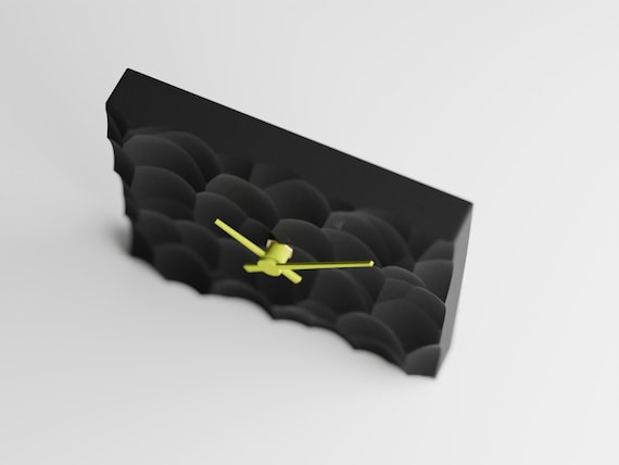 PrismHearth Table Clock, angled close-up of the Facetfield clock's two-color faceted body and contrasting hands