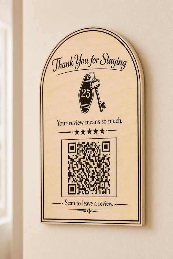 Keyhaven engraved birch guest review sign mounted on a warm cream wall from a close side angle with a finished sample QR code.