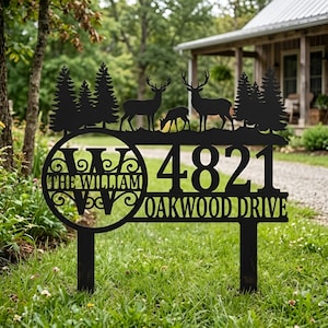 May include: A black metal garden sign featuring a silhouette of pine trees and three deer. The design includes a circular monogram with the letter W and the text THE WILLIAM, followed by the address 4821 OAKWOOD DRIVE in bold lettering.