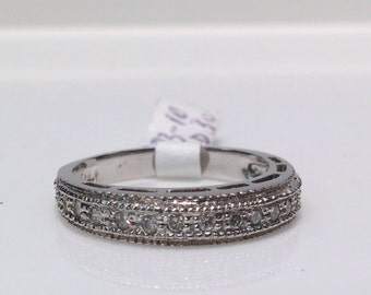 May include: A silver band ring with a row of small diamonds set in a delicate design.