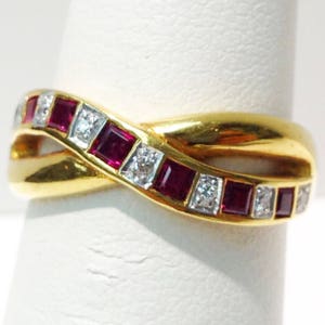 May include: A gold band ring with a twisted design. The band is set with alternating red rubies and clear diamonds.