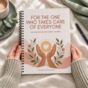 May include: A spiral-bound journal with a cream cover featuring the text FOR THE ONE WHO TAKES CARE OF EVERYONE AN UNDATED 90-DAY RESET JOURNAL. The cover art displays two hands cupping a glowing sun with a heart, surrounded by green foliage.
