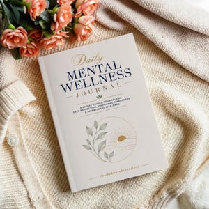 May include: A softcover journal with a cream-coloured cover titled Daily Mental Wellness Journal. The text includes A 28-day guided journal for self-reflection, emotional awareness & intentional self-care and TheMedNoteBlueprints with a leaf and sun graphic.