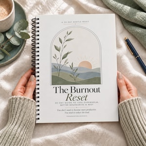 Può includere: Un quaderno a spirale intitolato The Burnout Reset, A 30-Day Gentle Reset. La copertina presenta un grafico di un sole che sorge su colline ondulate e rami frondosi all'interno di un arco. Il testo include 30-Day Guide to Less Overwhelm.