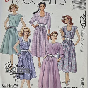 May include: Vintage McCall's sewing pattern featuring five dress designs. The cover showcases illustrations of the dresses in various colors and patterns, including polka dots and plaid. The pattern includes the text "Easy McCall's" and size information.