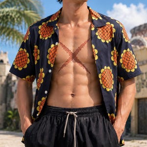 May include: A short-sleeved button-down shirt in black featuring a repeating pattern of orange and yellow sunflowers. The shirt has a classic collar and white buttons down the front. It is paired with black drawstring shorts with a light-colored cord.