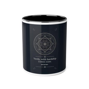 Peut inclure: Un mug en céramique bleu marine foncé avec un intérieur noir et un bord blanc. L'avant présente un motif de mandala en étoile géométrique blanc au-dessus du texte : Verily, with hardship comes ease. QURAN 94:5, centré en police serif.