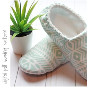 May include: A pair of soft, patterned slippers in a mint green and white geometric design. The slippers have a white, fluffy interior and a decorative trim around the opening. The words "digital pdf sewing pattern" are printed on the left side.