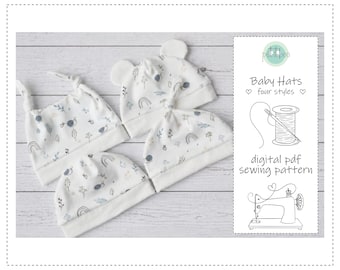 May include: Four baby hats in various styles, each with a white background and a playful pattern of rainbows, snails, and leaves in gentle blue and grey hues. The hats are arranged on a light wood-effect surface. A digital PDF sewing pattern is also shown.