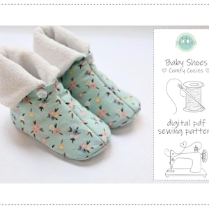 May include: A pair of baby shoes with a floral pattern in shades of blue, pink, and yellow. The shoes have a soft, white, fluffy lining and a button closure. The image also includes text that reads "Baby Shoes Comfy Cozies" and "digital pdf sewing pattern".