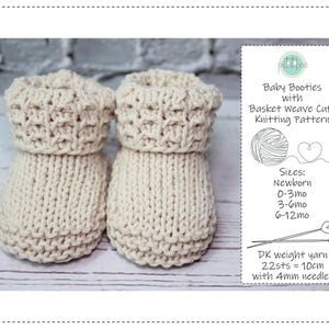 Op de afbeelding: Een paar crèmekleurige baby slofjes met een mandvlecht manchet ontwerp. De slofjes zijn gebreid en liggen op een lichtgekleurd houten oppervlak. De afbeelding bevat de tekst "Baby Booties with Basket Weave Cuff Knitting Pattern".
