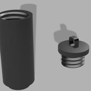 May include: A matte black cylindrical container with an open top showing internal threading and a separate matching black circular lid featuring a small square loop on the top surface and external threading designed to screw into the container.