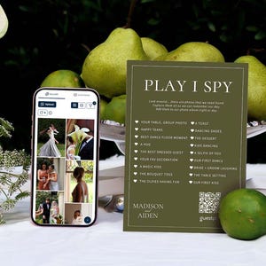 Puede incluir: Un teléfono inteligente que muestra una aplicación de galería de fotos junto a una tarjeta rectangular de color verde oliva titulada PLAY I SPY con una lista de sugerencias de fotos de boda, un código QR y los nombres Madison y Aiden.