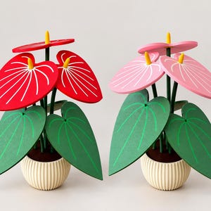 May include: Two decorative potted plants featuring heart-shaped leaves and flowers. One plant has bright red flowers with yellow centers, and the other has light pink flowers with yellow centers. Both have green leaves and cream-colored ribbed pots.