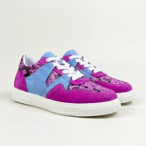 May include: A pair of low-top trainers featuring a vibrant magenta suede toe and heel, accented by light blue suede overlays and a snakeskin-patterned leather panel in shades of purple and black. The shoes include white laces and a thick white sole.