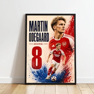 May include: A framed poster featuring Martin Odegaard in an Arsenal soccer kit. The design includes a large red number 8, the text MARTIN ODEGAARD ARSENAL, and a dynamic red and blue paint splatter effect surrounding the player in action.